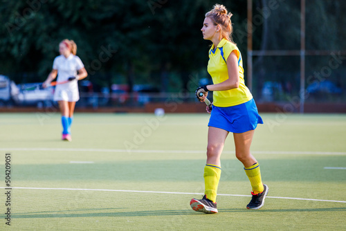Young field hockey female player with stick during the game. Image with copy space © skumer