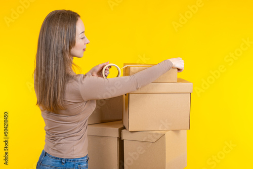 Woman seals box with tape. ...