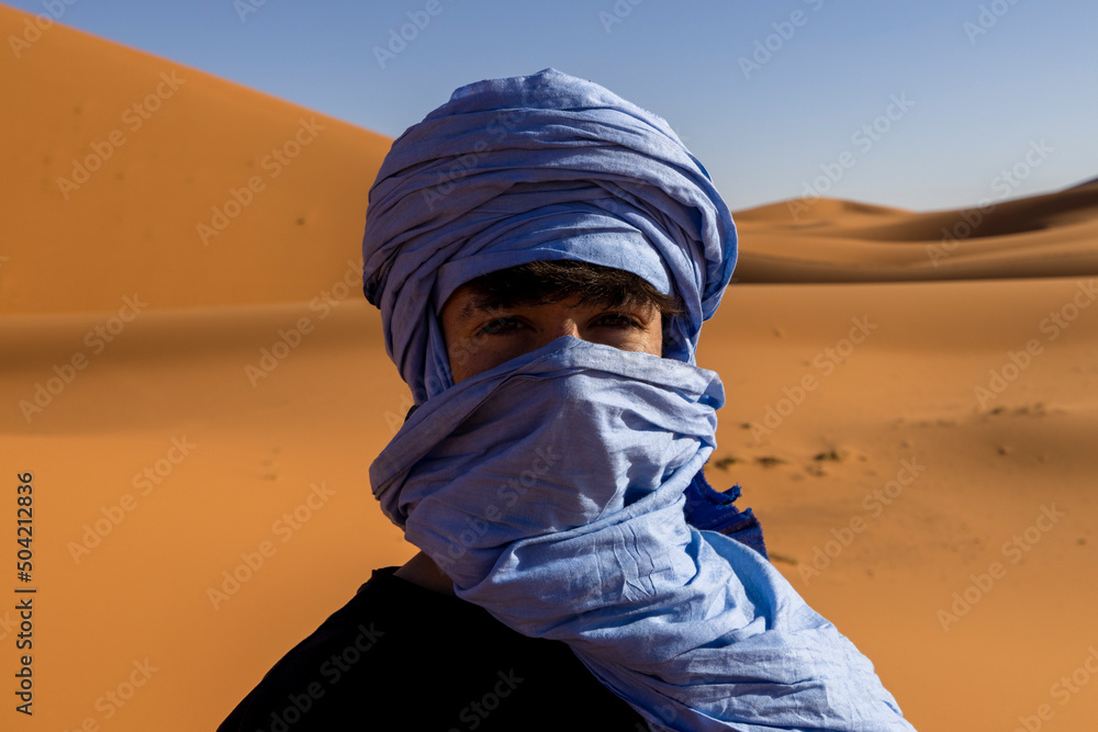 Joven con turbante azul en el desierto