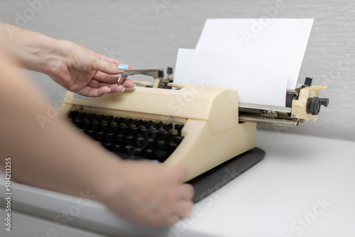 female hand shifts the typewriter carriage by pressing the lever photo