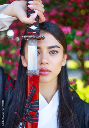 Canvas Print Elegant girl in traditional kimono in a blooming flowers garden with samurai jap