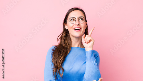 Photos young pretty woman smiling happily and looking sideways, wondering, thinking or