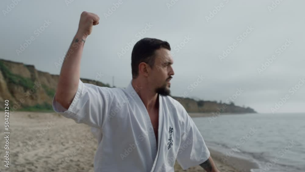Karate fighter exercising outdoors closeup. Man training martial exercises. Karate fighter exercising outdoors closeup. Man training martial exercises.