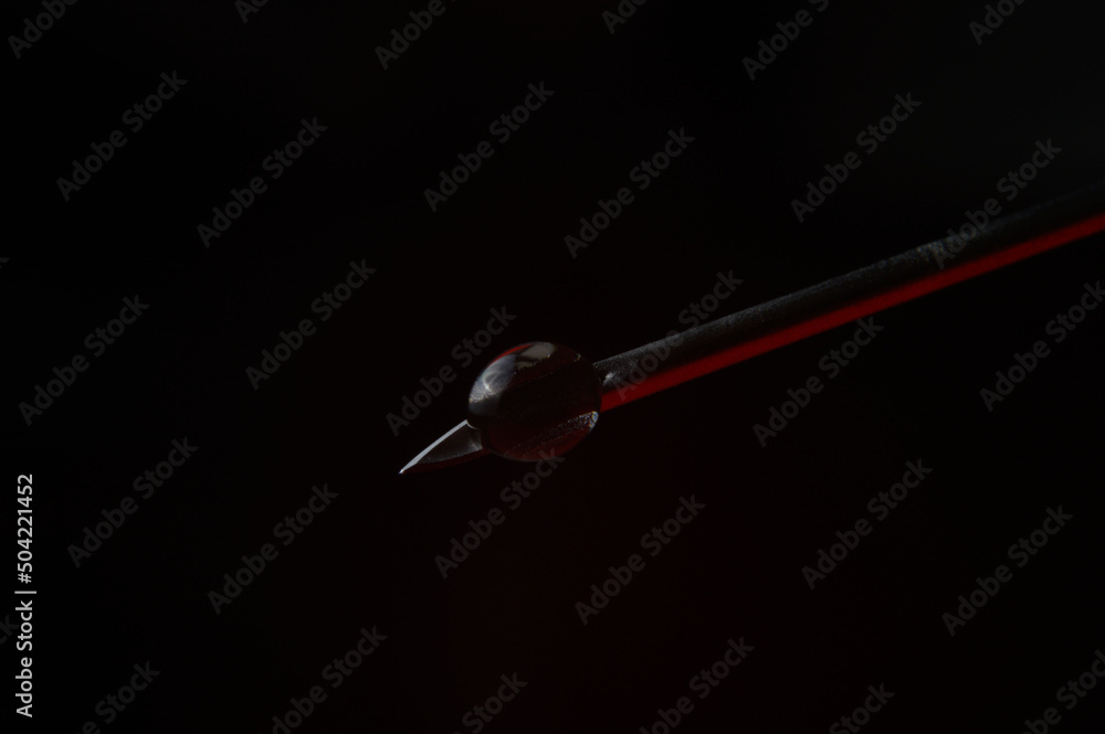 Syringe needle and a drop of a transparent substance. close-up Syringe needle and a drop of a transparent substance. close-up