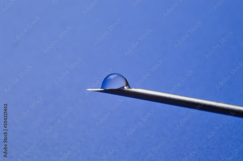 Syringe needle and a drop of a transparent substance. close-up Syringe needle and a drop of a transparent substance. close-up