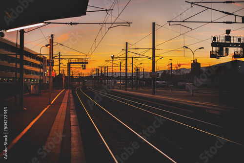 romantic view of railways by the train station on the sunset