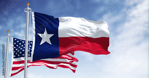The Texas state flag waving along with the national flag of the United States of America photo