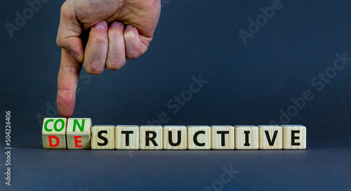 Destructive or constructive symbol. Businessman turns cubes and changes the concept word Destructive to Constructive. Beautiful grey background. Business constructive destructive concept. Copy space. photo