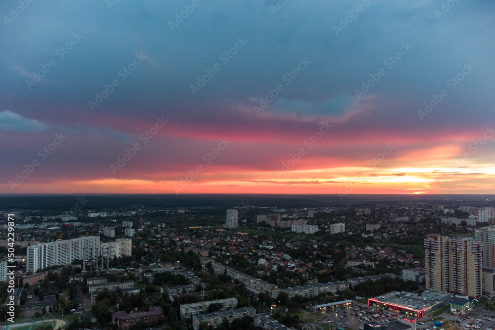 Beautiful colorful sunset above city residential district, aerial view. 23 serpnia, Pavlovo Pole, Kharkiv, Ukraine. Majestic evening cloudscape and streets