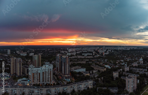Epic vibrant sunset aerial view in city residential multistory district. 23 serpnia, Pavlovo Pole, Kharkiv, Ukraine. Fly at dusk, evening cloudscape and urban streets