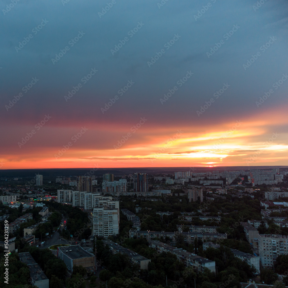 Epic vivid sunset above city residential district, aerial view. Pavlovo Pole, Kharkiv Ukraine. Majestic evening skyscape, cloudscape and houses