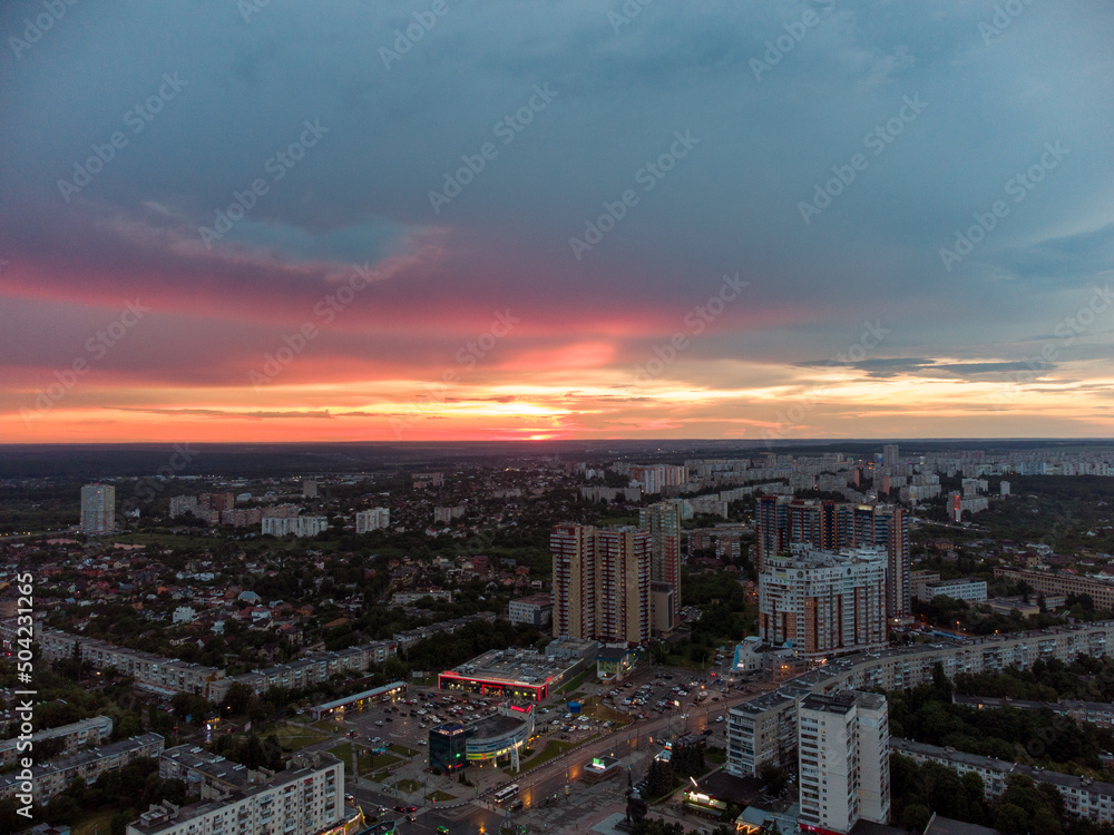 Epic vibrant sunset aerial view in city, residential district. 23 serpnia Pavlovo Pole Kharkiv, Ukraine. Fly with majestic evening cloudscape and city lights