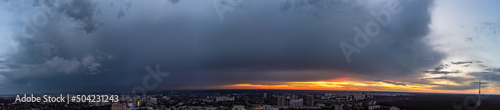 Dramatic wide orange sunset cloudscape panorama view in city residential district. Aerial Pavlovo Pole, Kharkiv, Ukraine. Evening skyscape, cloudscape and streets