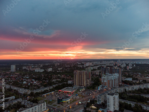 Epic vibrant sunset aerial view in city  residential district. 23 serpnia Pavlovo Pole Kharkiv  Ukraine. Fly with majestic evening cloudscape and city lights