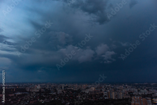 Aerial evening view on city with dramatic heavy sunset sky with clouds. Evening flight above city streets. Kharkiv  Ukraine city center park and residential district