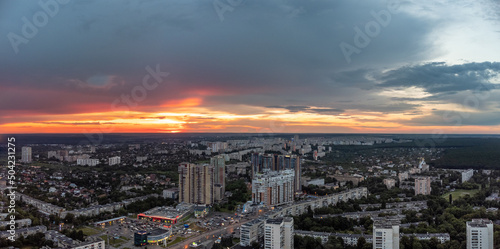 Epic vivid sunset above city residential district, aerial view. 23 serpnia, Pavlovo Pole, Kharkiv, Ukraine. Majestic evening skyscape and city streets