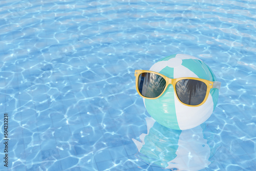 sunglasses on inflatable ball in swimming pool