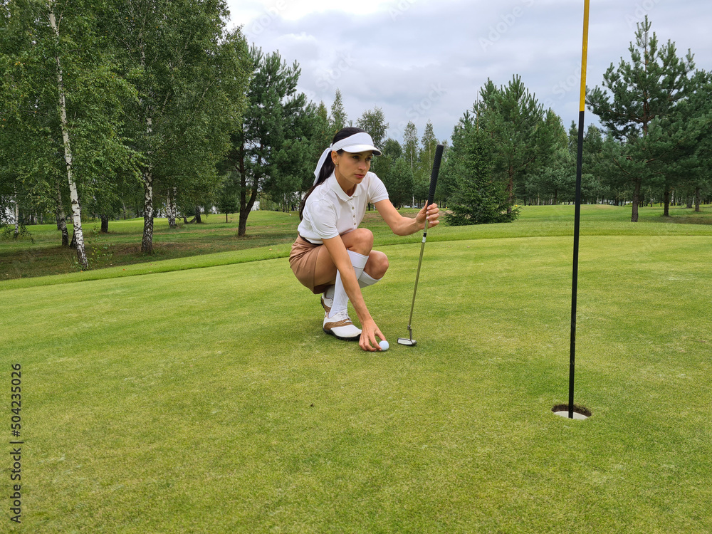 Obraz premium Golfer flattens ball on green before making hole