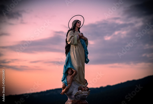 Bella escultura de la Virgen María al amanecer photo