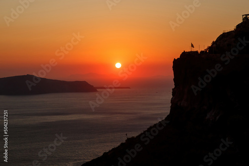 Sunset over Aegean sea and rock on Santorini island, Greece