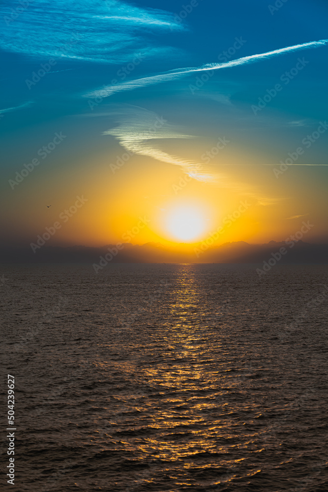On the horizon is the sun sky sea clouds bird