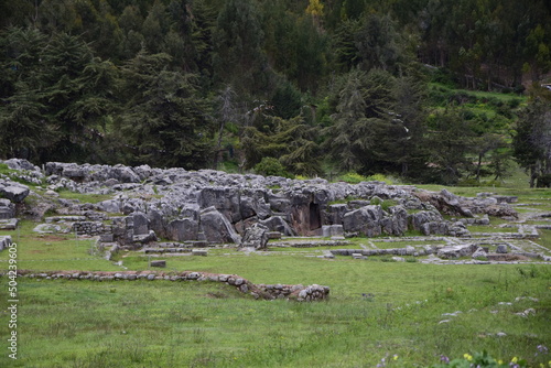 A field with green grass in front of the Inca ruins Saqsaywaman near Cusco. photo