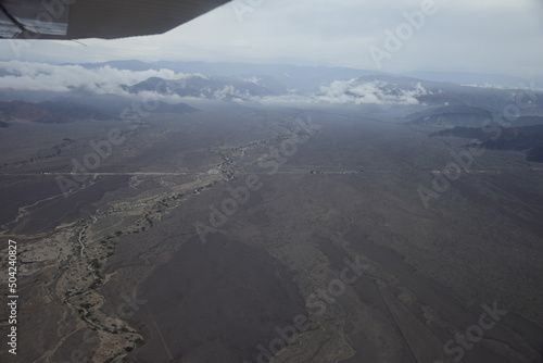 View from under the wing of an airplane on the surroundings of the Nazca. It is the largest town in Nazca Province