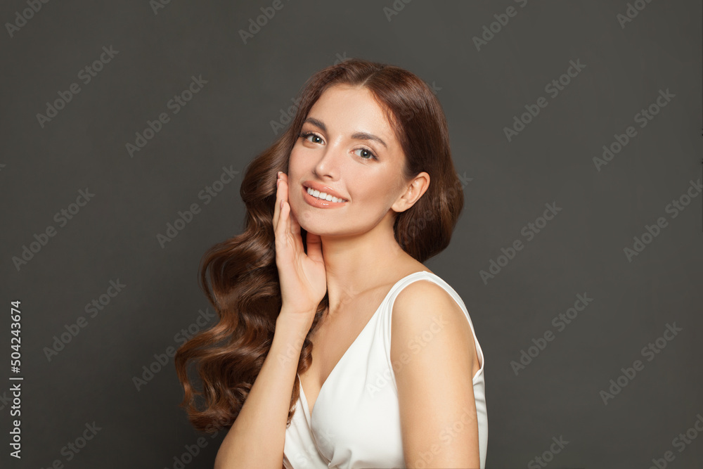 Portrait of beautiful attractive fashion model with long shiny wavy brown hair smiling on black background Portrait of beautiful attractive fashion model with long shiny wavy brown hair smiling on black background