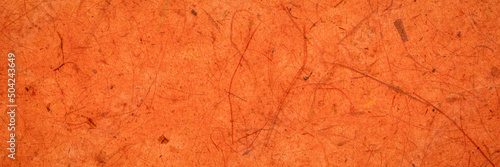background of amber and orange backlit, handmade, mulberry paper with leaf and fine inclusions, panoramic web banner