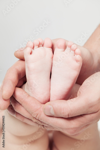 Soft gentle newborn baby feet in parent hands