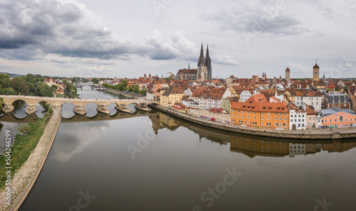 Panorama der Stadt Regensburg in Bayern mit dem Fluss Donau dem Dom und der steinernen Brücke im Sommer bei bewölktem Himmel, Deutschland