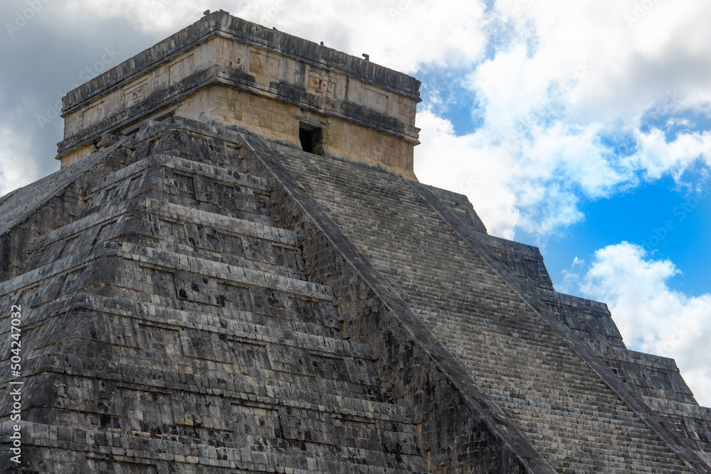 Step Pyramid of Kukulkan against a cloudy sky. Ancient Mayan city, Chichen Itza, Yucatan, Mexico. Old discolored masonry.