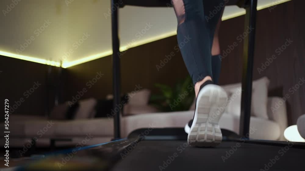 female feet running on treadmill in sport shoes, close up female feet running on treadmill in sport shoes, close up