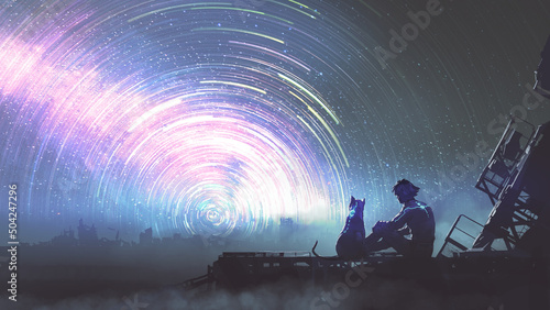 Photographie man and his pet in futuristic suit siting and looking at the star trail in the s