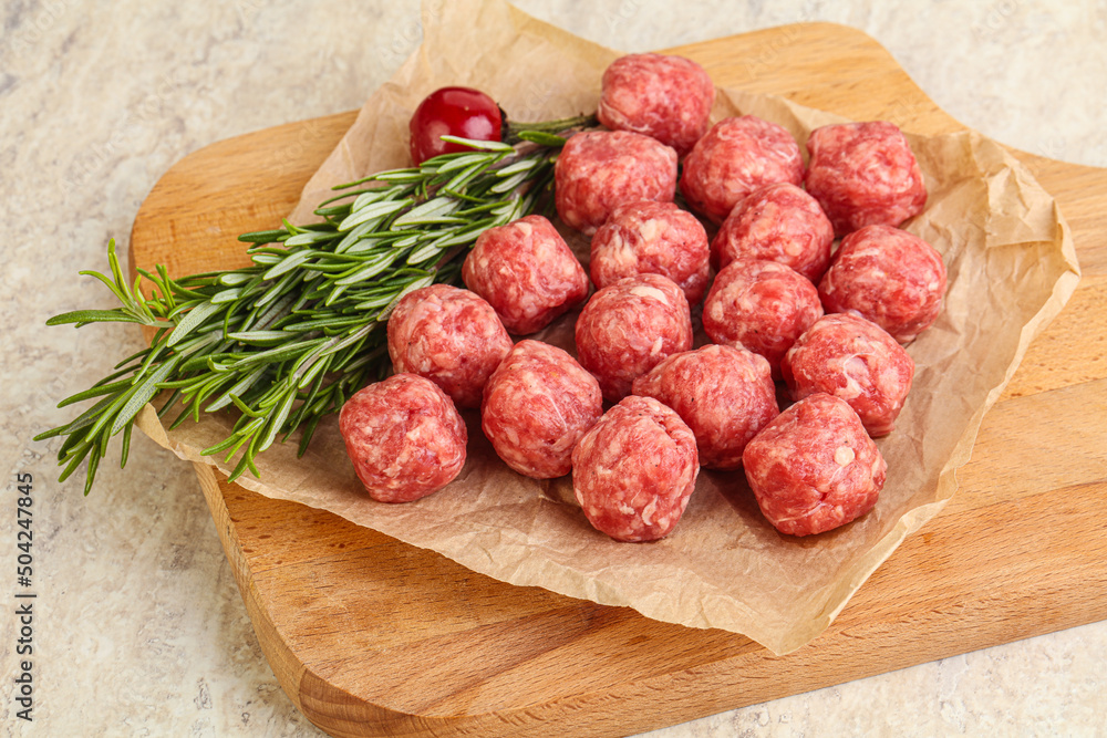 Raw uncooked beef meatballs served rosemary