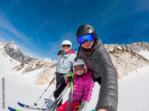 Happy young family taking a selfie at skiing resort.