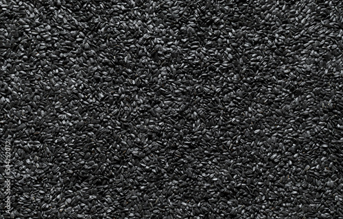Black sunflower seeds background, above view.