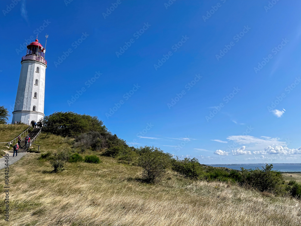 The Hiddensee Dornbusch Light House with surrounded green nature and blue sky background The Hiddensee Dornbusch Light House with surrounded green nature and blue sky background