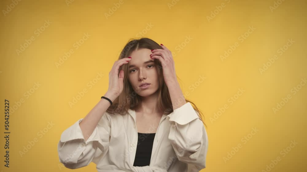 Young adult caucasian woman is ... on a bright yellow background in studio Young adult caucasian woman is ... on a bright yellow background in studio