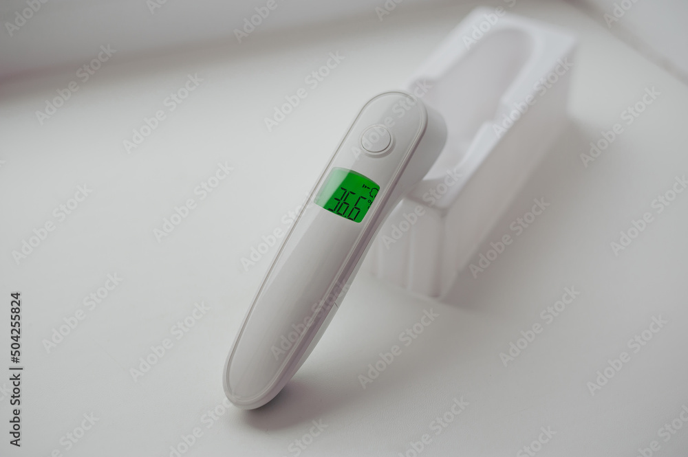 Non-contact thermometer on a white background for measuring body temperature Non-contact thermometer on a white background for measuring body temperature
