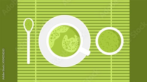 White cup with a Japanese green matcha tea, saucer and spoon with a powder on a green bamboo mat on white background. Top view