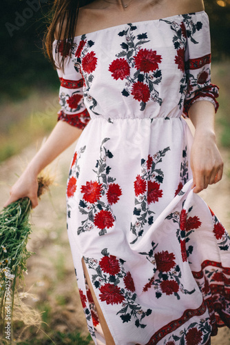 Ukrainian woman in beautiful national clothes with flowers in her hands (daisies)