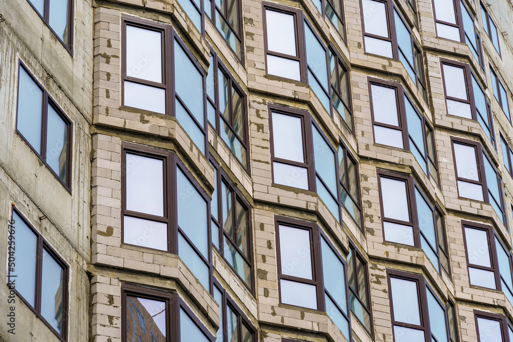 construction of a modern high-rise building, exterior of a apartment house under construction with new windows construction of a modern high-rise building, exterior of a apartment house under construction with new windows