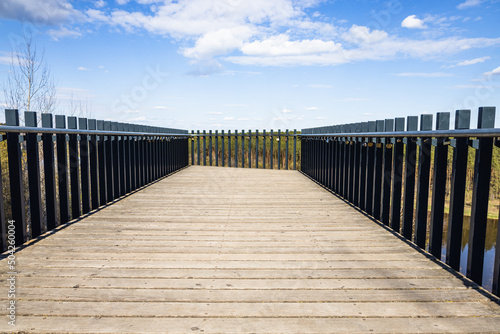 Wooden platform with steel handrails and love padlocks hanging on it