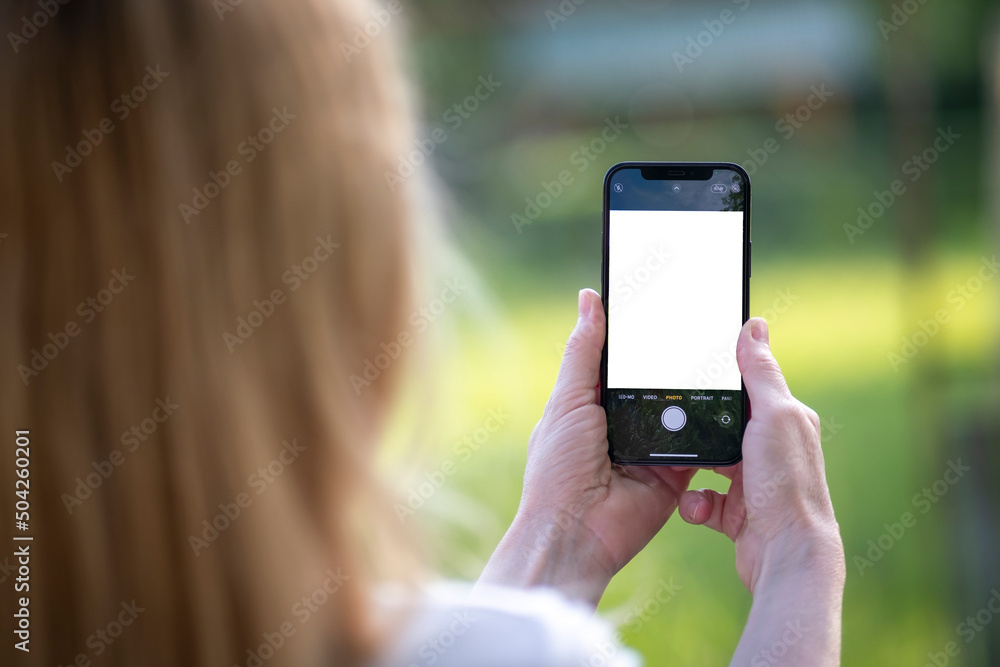 Woman holding phone and taking pictures. Blank screen Woman holding phone and taking pictures. Blank screen
