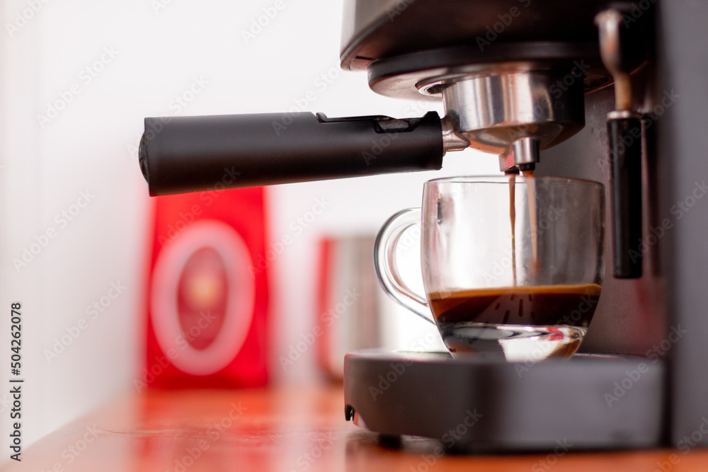 Instant coffee machine preparing coffee in a half-filled transparent cup. Instant coffee machine preparing coffee in a half-filled transparent cup.