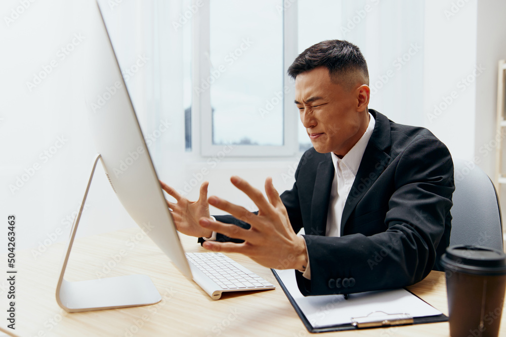 manager in a suit glass of coffee sits at a tablein front of a computer technologies manager in a suit glass of coffee sits at a tablein front of a computer technologies