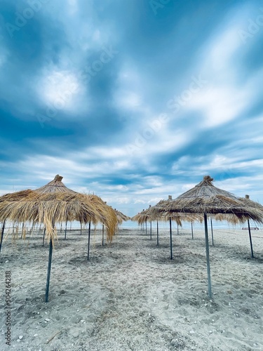 Straw beach umbrellas on a blue sky and sea background.Copy space 