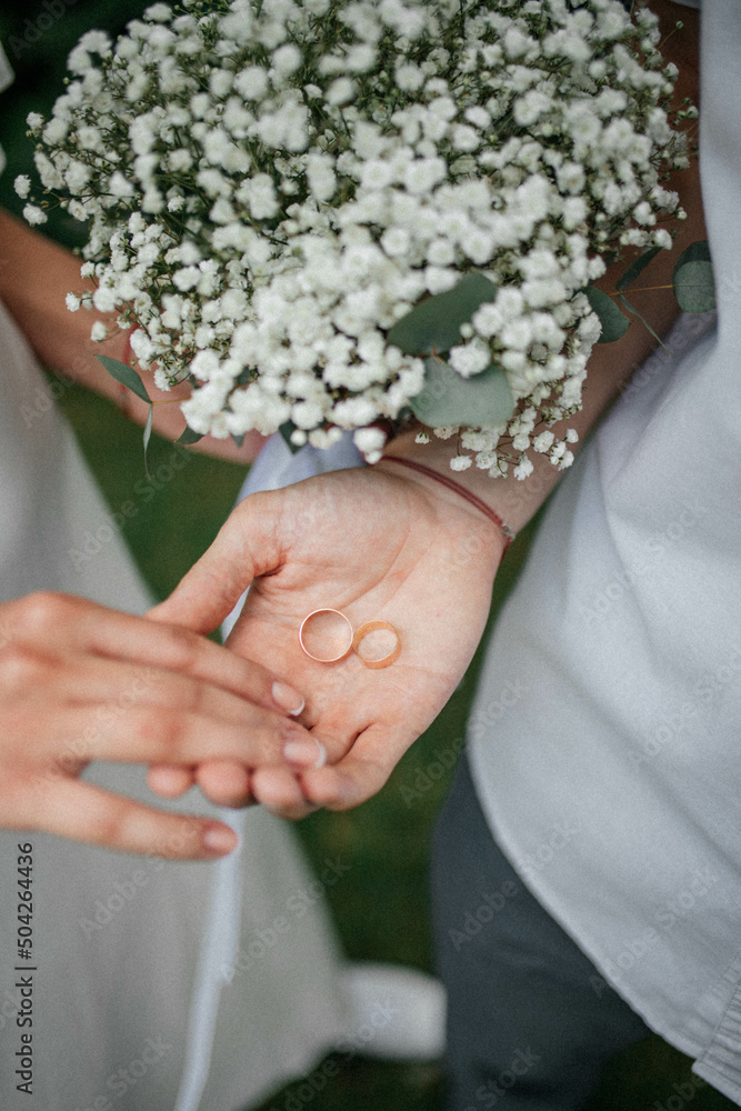 bride and groom holding rings in their hands bride and groom holding rings in their hands
