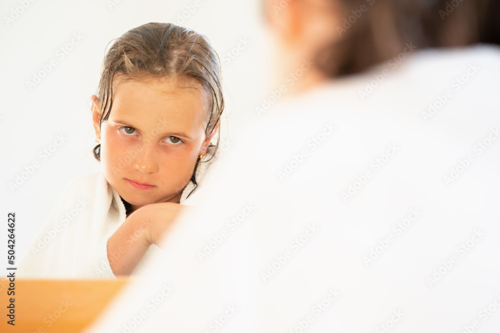 Beautiful young girl relaxing in spa bathrobe in front of mirror after the shower. Copy space. Beautiful young girl relaxing in spa bathrobe in front of mirror after the shower. Copy space.